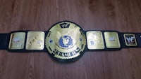 a wwe championship belt on a wooden floor
