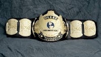 a black and gold wrestling belt on a black background